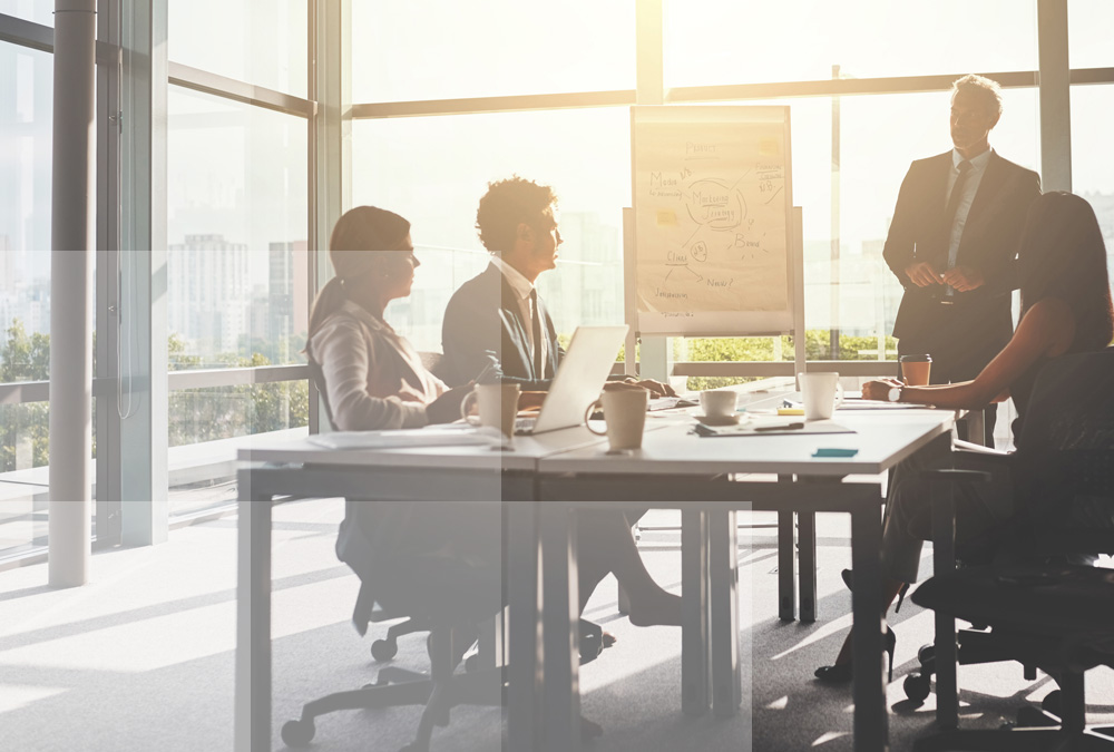 A group of colleagues in a meeting utilizing Datasite's virtual data room